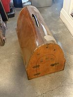 Side view showing arched bentwood form, ventilation holes, front door and overall structure