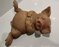 Top view of resin piglet figurine lying on its back