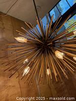 Underside view of brass-tone Sputnik chandelier with illuminated bulbs