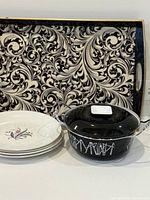 Group shot showing tray, stack of four plates, enamel pot with lid