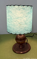 Full view of copper lamp with turquoise fiberglass shade illuminated