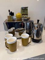 Front view showing toaster, percolator, three mugs