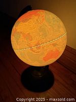 Illuminated globe showing continents, on pedestal