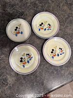 Four vintage Mickey Mouse plates on countertop