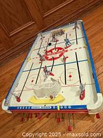 Angled view of full game showing players, nets, rods and puck