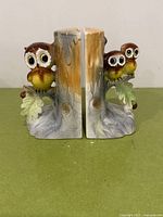 Front view of both ceramic owl bookends showing owls, leaves, and stump detail