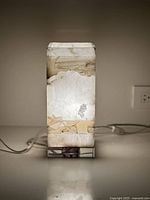 Front view of illuminated onyx agate column light showing stone pattern and lucite base