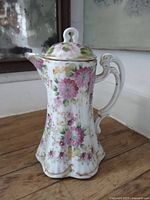 Full view of pot showing floral design, handle and lid