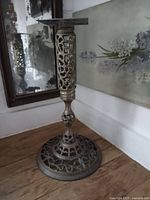 Side view of brass pedestal showing pierced foot and column