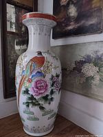 Front view of painted porcelain floor vase beside wall art