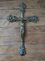 Full view of brass crucifix on wood background