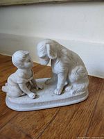 Front view of Parian-style figurine showing child and dog and inscription