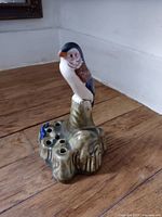 Front view of ceramic parrot flower frog showing parrot figure and stem holes