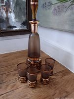 Full view of decanter and four glasses on floor