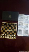 Chess set with closed box, open board, pieces and instructions visible