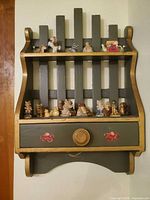 Front view of wall shelf with drawer and figurines displayed