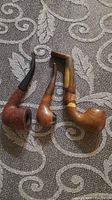 Three smoking pipes laid side-by-side showing bowl shapes and stems