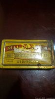Top view of yellow Millbank Virginia Cigarettes tin