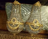 Front view of both gilt bronze and crystal sconces