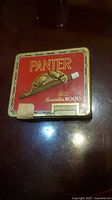 Front view of red Panter cigarillo tin