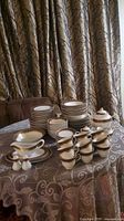 Entire set stacked on table showing plates, bowls, cups, teapot, sugar, creamer, gravy boats, salt & pepper