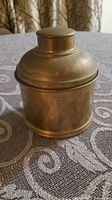 Front view of brass canister with lid in place