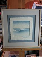 Full view of framed artwork on easel