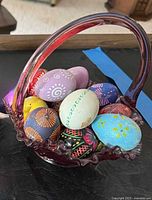 Art glass basket containing hand-painted eggs