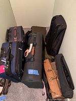 Group shot of all luggage pieces: two rolling suitcases, two garment bags, and three duffels