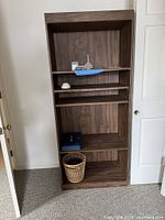 Front view of bookcase showing five shelves and wood-grain finish