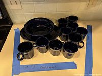 Full set showing ten mugs, two nested serving bowls, and one serving plate in cobalt blue glaze