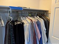 Closet rod with numerous men’s dress shirts, pants, sport coats, neckties and hangers
