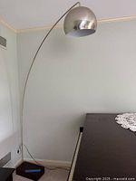 Full view of arc floor lamp showing curved arm and dome shade
