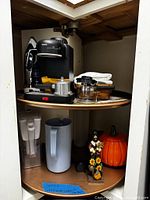 Entire lot on lazy susan shelf, showing espresso machine, pitchers, basket, ceramics