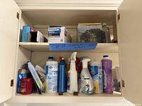 Cabinet left section with cleaning supplies and light bulb boxes