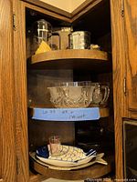 Cabinet with Bodum press, flour sifter, crystal bowl, fish plates