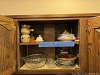 Open cabinet showing all serveware and dinnerware pieces