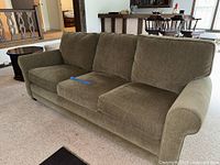 Front view of olive/khaki three-seat sofa showing cushions and rolled arms