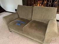 Front view of olive/khaki loveseat showing cushions and arms