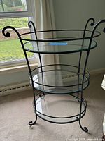 Full view of round 3-tier glass and metal stand