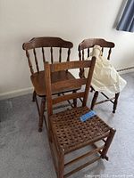 Two spindle-back chairs, one ladder-back rocker, rag doll on seat