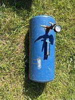 Full view of blue portable air tank on grass showing overall condition