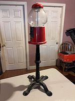 Full front view of gumball machine on stand