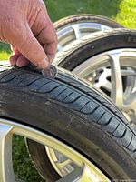 Tread depth of one tire with coin for scale