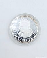 Obverse view of 1984 Pope John Paul II silver coin in capsule
