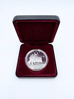 Coin in capsule inside burgundy Royal Canadian Mint clamshell case