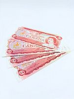 Fanned view of multiple $2 Canadian banknotes showing front design details