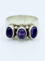 Front view of sterling silver ring showing three amethyst cabochons