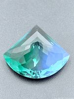 Front view of the faceted bi-colour gemstone showing blue to green gradient