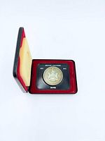 Coin inside open case showing obverse and plastic holder text